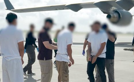 ICE Agents escort shackled detainees toward an airplane for a deportation flight to Honduras. (Photo by ICE/Dept. of Defense)
