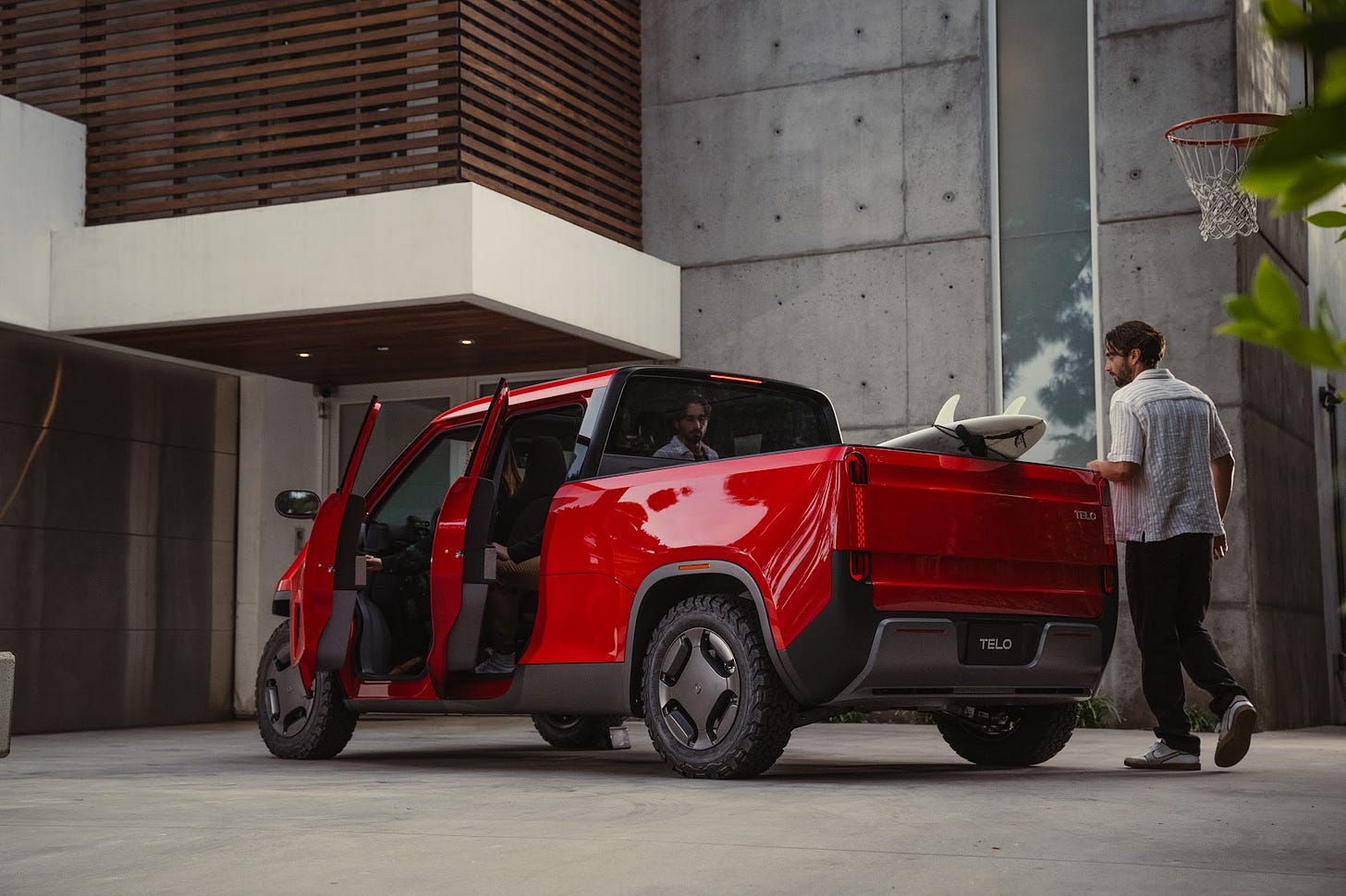 A top down view of a couple walking on a San Francisco street with an orange TELO MT1 behind them tightly parked in between two other cars.