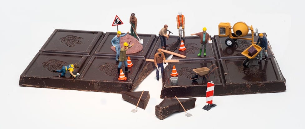 3 men sitting on black and yellow train toy