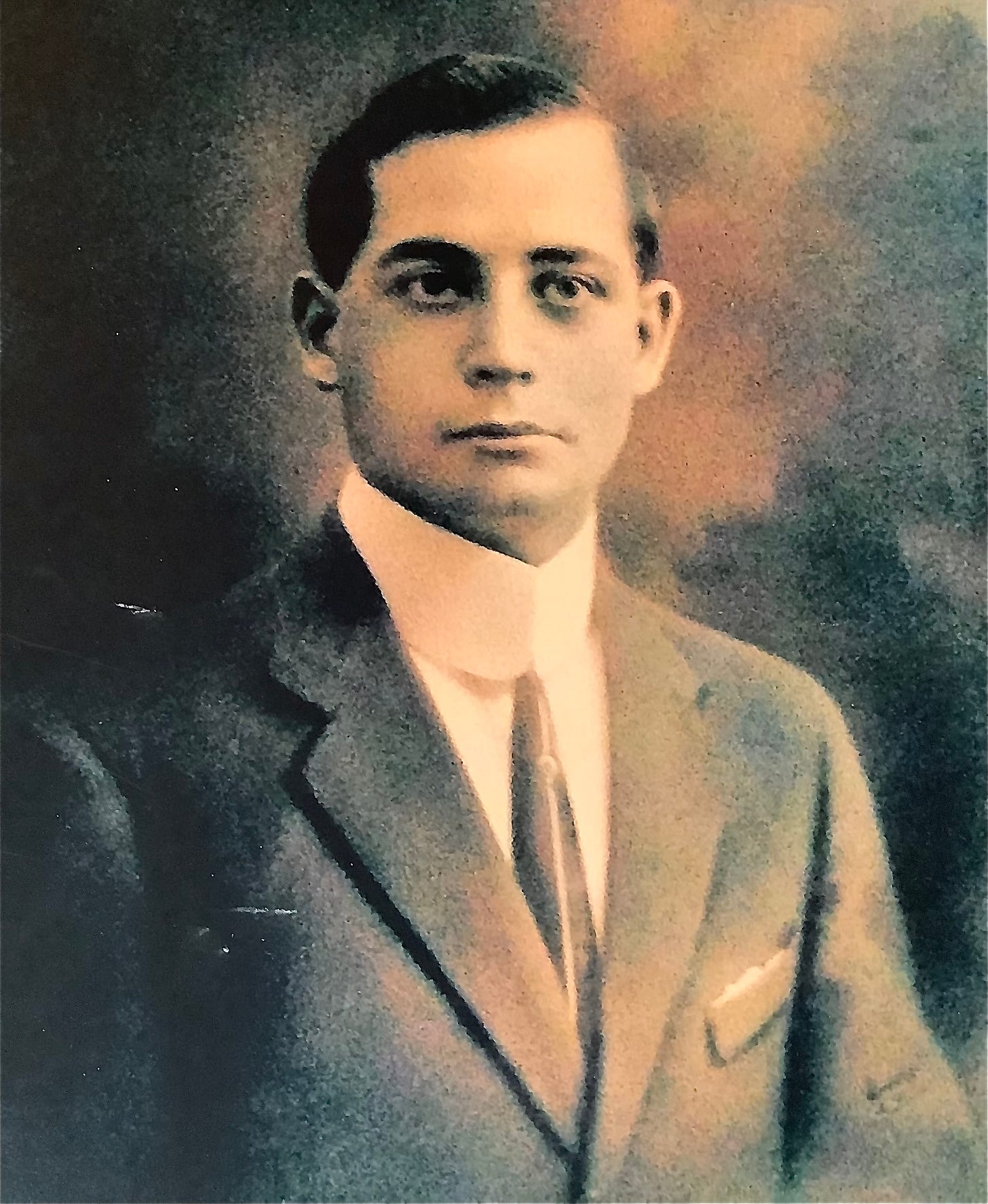 A black and white studio portrait of a young Italian man in a suit, tie and high collared shirt of the 1920s or 30s
