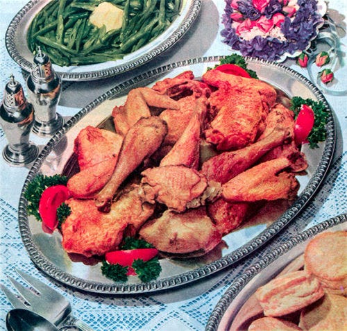 Friend chicken with various dinner items on a table.