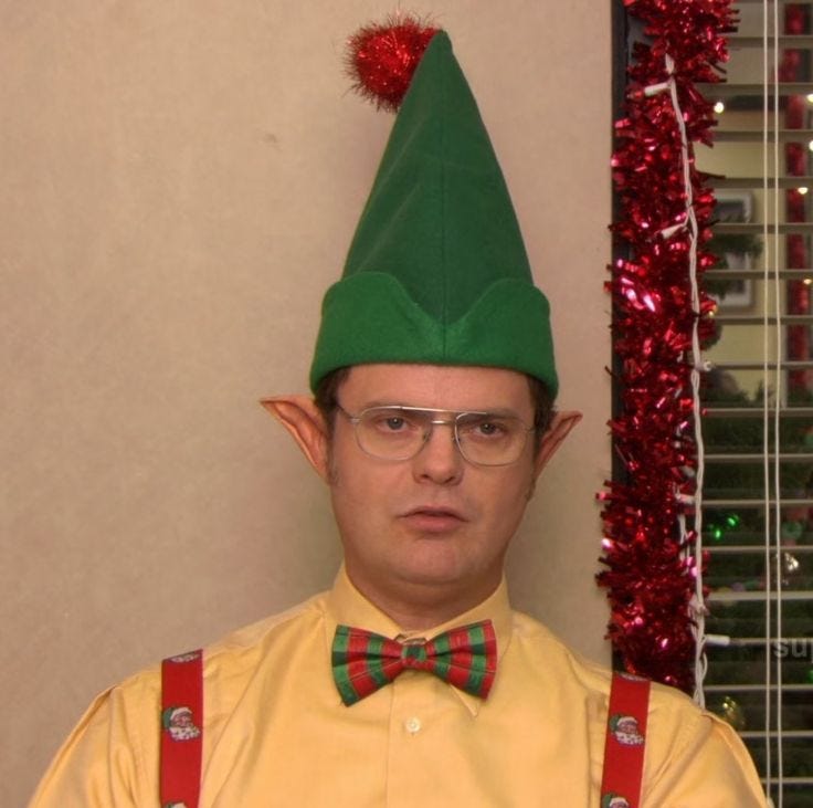 This may contain: a man wearing a green elf hat and bow tie with suspenders on his head This may contain: a man wearing a green elf hat and bow tie with suspenders on his head