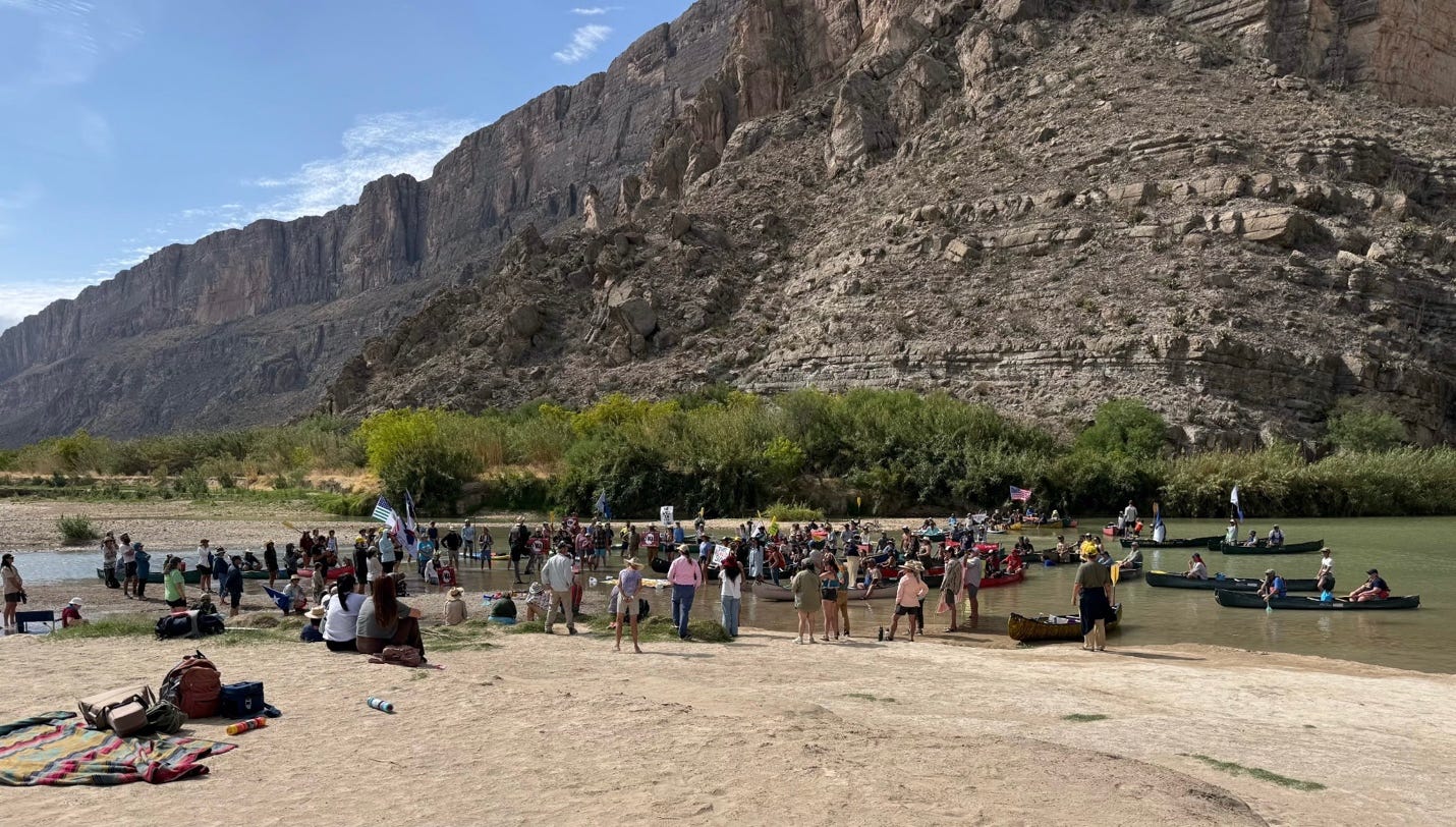 A group of people standing in a river

Description automatically generated