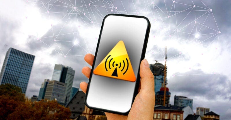 hand holding cellphone with electromagnetic radiation symbol