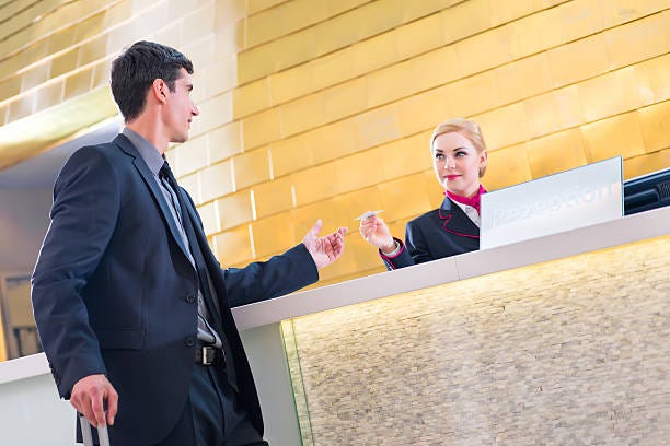 Hotel receptionist check in man giving key card Man in Hotel check in at reception or front office being given key card Cloud Property Management  in hotel front desk stock pictures, royalty-free photos & images