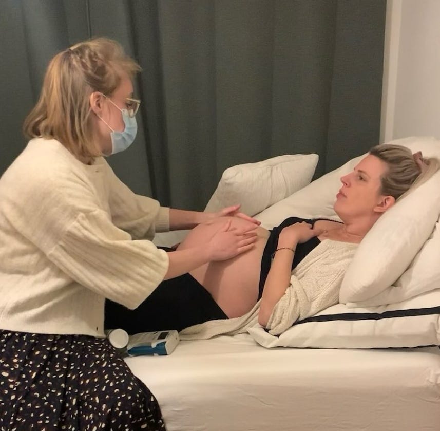 pregnant woman on bed with midwife