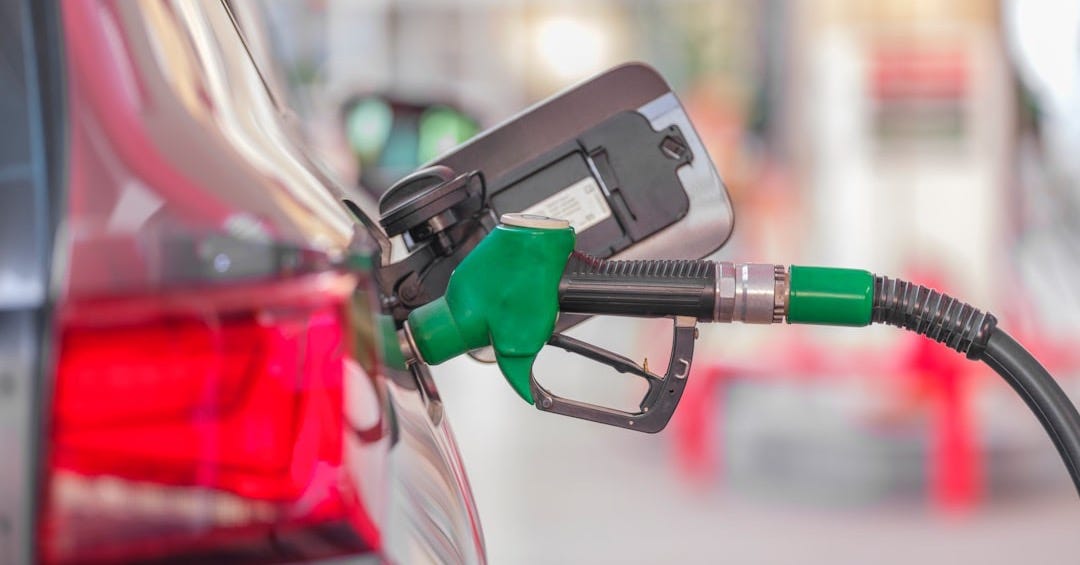 a gas pump is connected to a car at a gas station a gas pump is connected to a car at a gas station