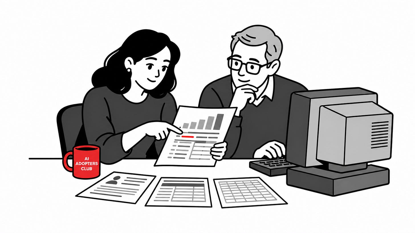 Two colleagues review the same client report beside an older desktop computer and three source sheets; a small red AI Adopters Club mug sits on their desk.