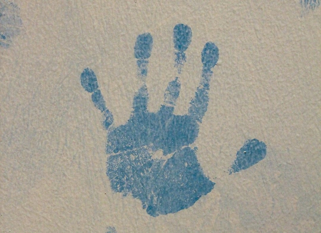 A picture of a hand and foot print on a wall A picture of a hand and foot print on a wall