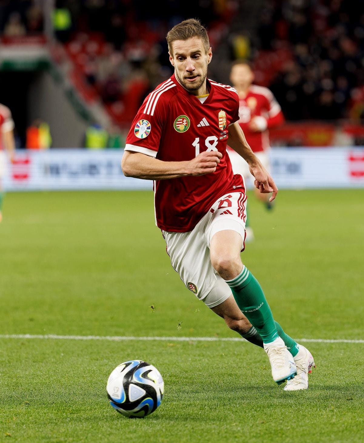 A person in a red jersey running with a ball

Description automatically generated