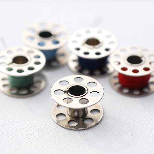 bobbins with and without thread on a white background