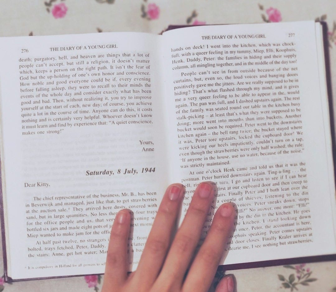 person holding book page on white floral textile person holding book page on white floral textile