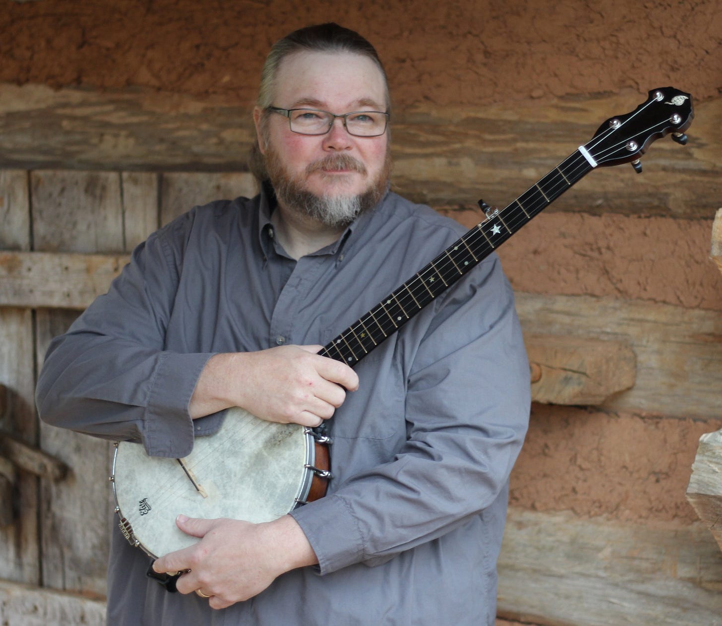 A photo of a Riley Baugus. He is a bearded man holding a banjo.