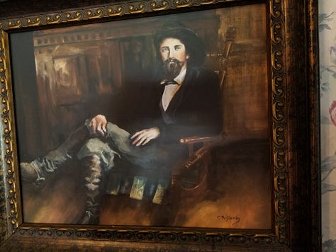 The Dickson Williams Mansion, a brick building with a white porch; the parlor, showing a round table surrounded by black chairs on a red oriental rug in front of a fireplace; the kitchen area, showing original north carolina furniture; bedrooms of the house, along with a portrait of General John Hunt Morgan sitting in a chair in a black coat with tall black boots; and the bed where he spent his last night.