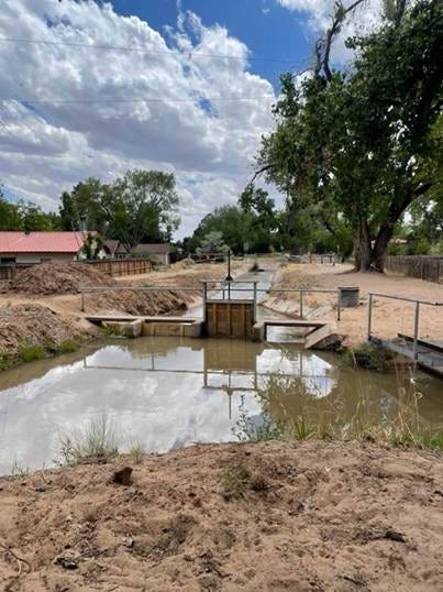 A small pond with a gate and a fence

AI-generated content may be incorrect.
