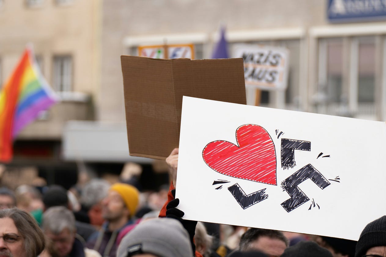 Photo of heart overtaking a swastika by Mika Baumeister on Unsplash Photo of heart overtaking a swastika by Mika Baumeister on Unsplash