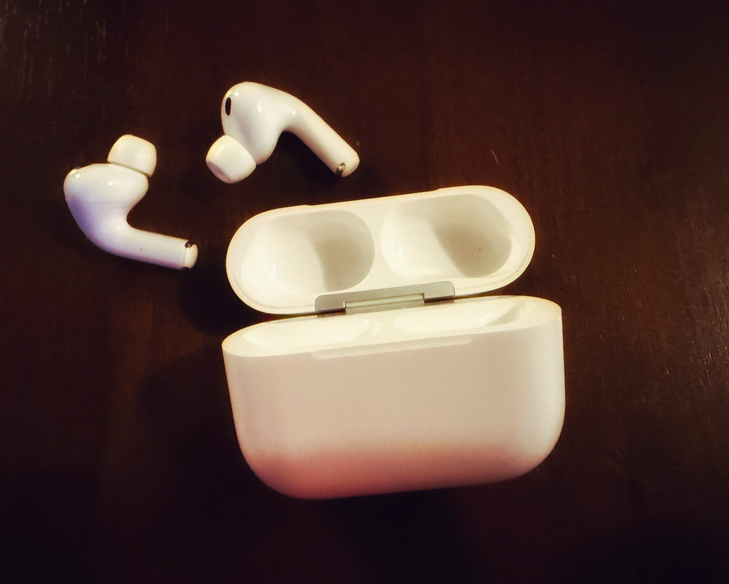 Open AirPods and Case on a table Open AirPods and Case on a table