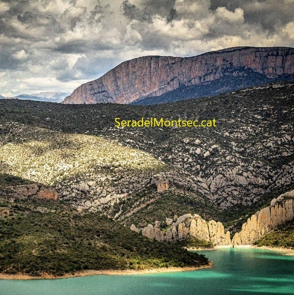 Vista des de La Vulturina, Estopanyà, de Les Roques de la Vila del despoblat de Finestres i, a sobre, l’anomenada Paret de Catalunya que forma part del Congost de Mont-rebei. Montsec de l’Estall. Viacamp i Lliterà, Ribagorça d’Osca, Aragó.