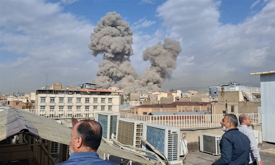 People watch as smoke rises on the skyline after an explosion in Tehran, Iran, on Feb. 28.