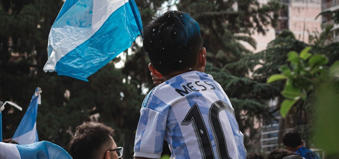 a young boy holding a blue and white flag a young boy holding a blue and white flag