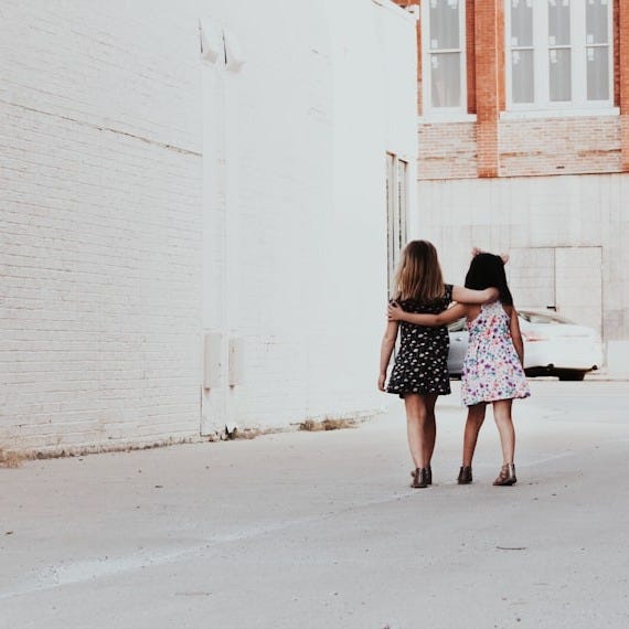 two girls walking on street
