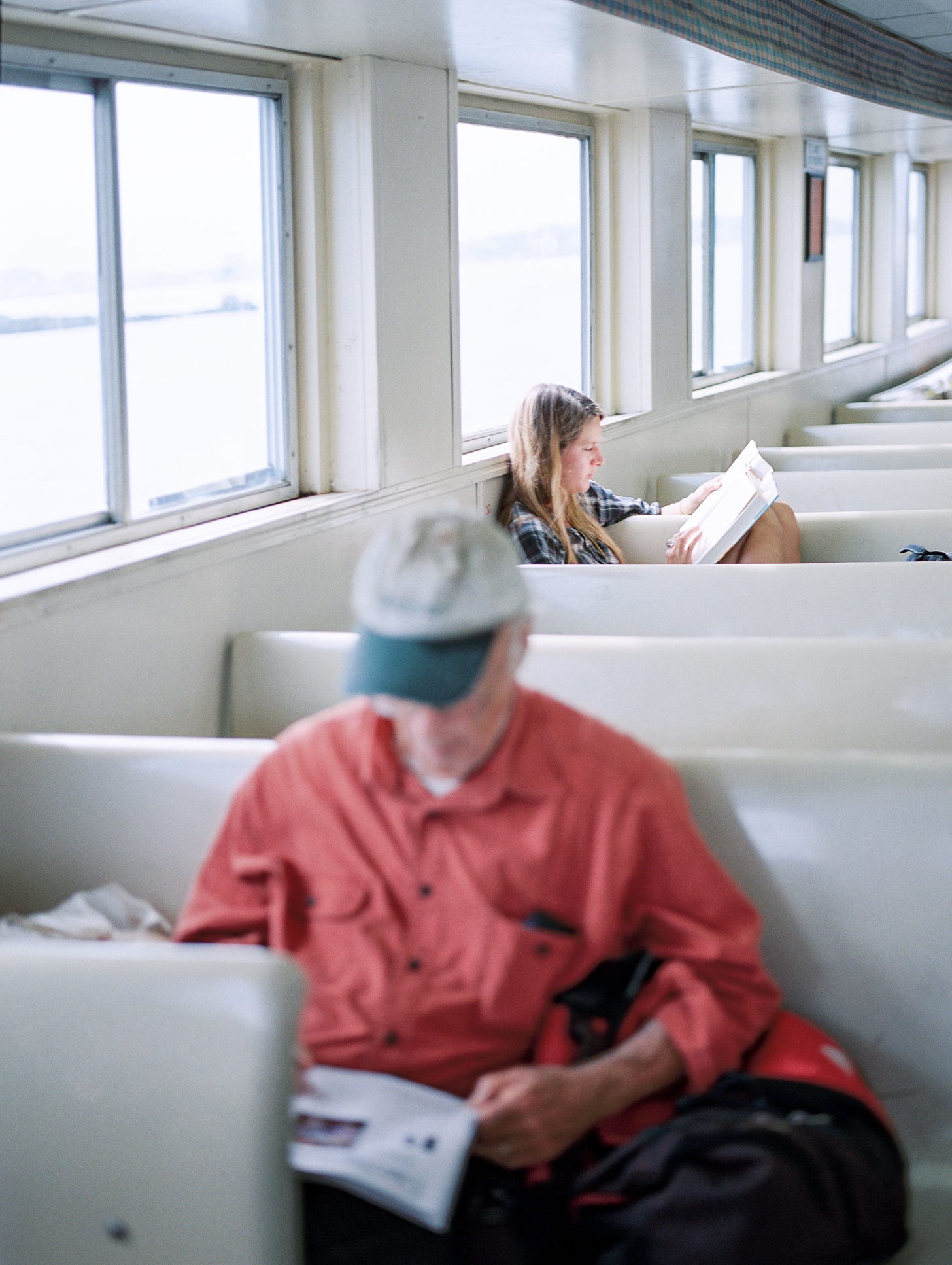 A photo of two people reading on a ferry A photo of two people reading on a ferry
