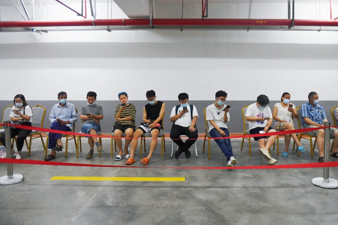 People browse their phones while waiting to receive a Covid-19 vaccine in Hangzhou, East China's Zhejiang province, on Aug. 27, 2021. Photo: VCG