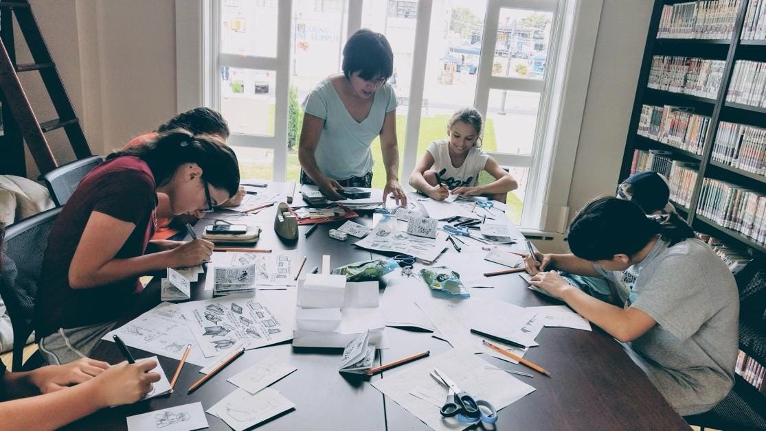 A group of people working at a table

Description automatically generated with medium confidence