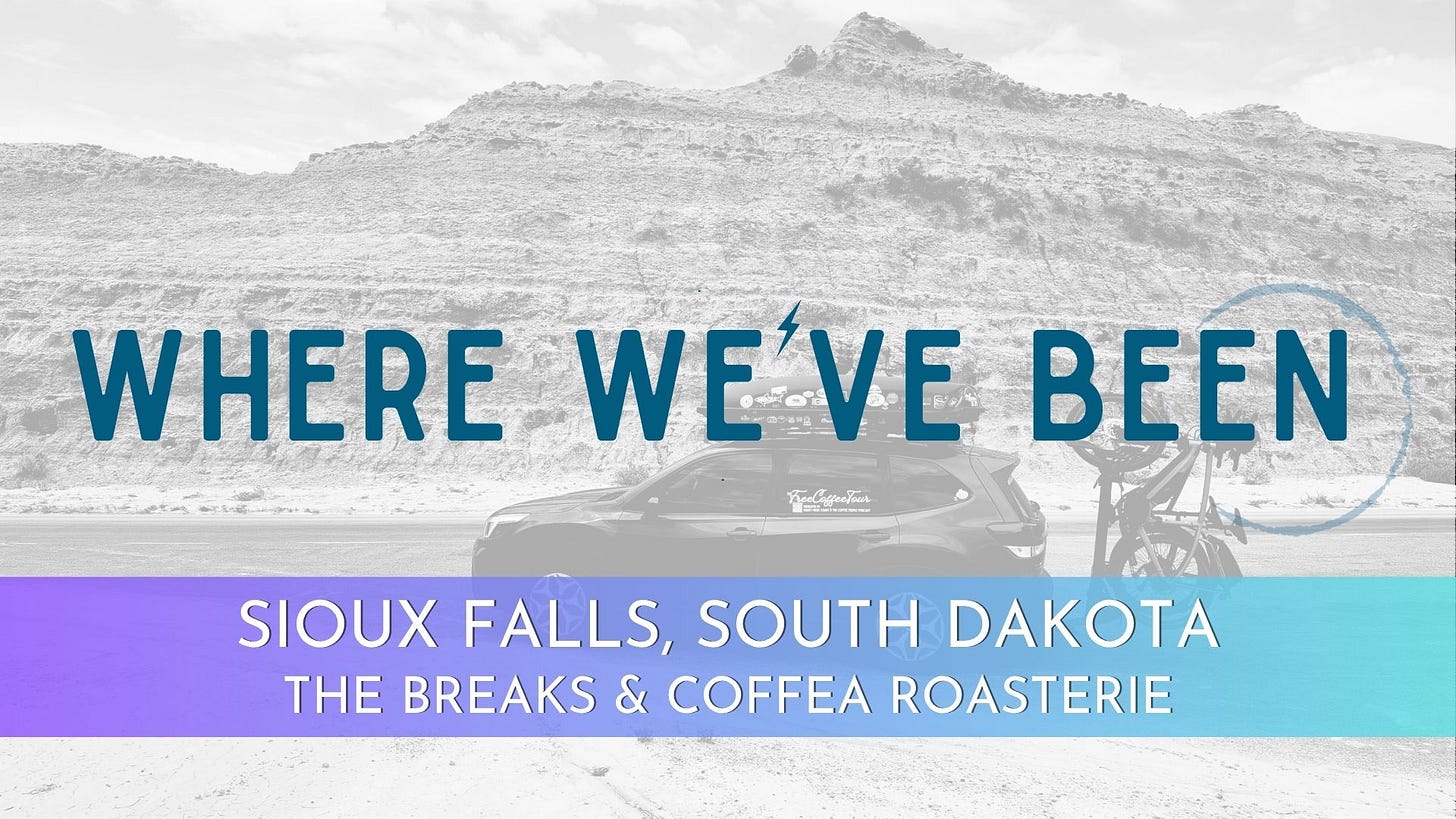 Header image background is a black and white photo of a Subaru Forrester SUV with stickered rooftop cargo boxes and a bike rack off the back parked in front of a striated rock mound jutting into a blue sky dotted with clouds in the Badlands of South Dakota.