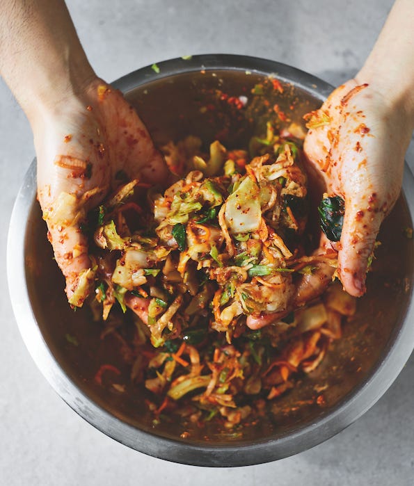 Two how to photos. On left hands cutting red cabbage with chilis on the side. On the right hands mixing kimchi in a bowl. 