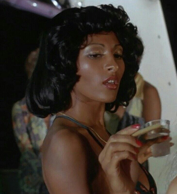 This may contain: a woman holding a wine glass in her right hand and looking at the other side