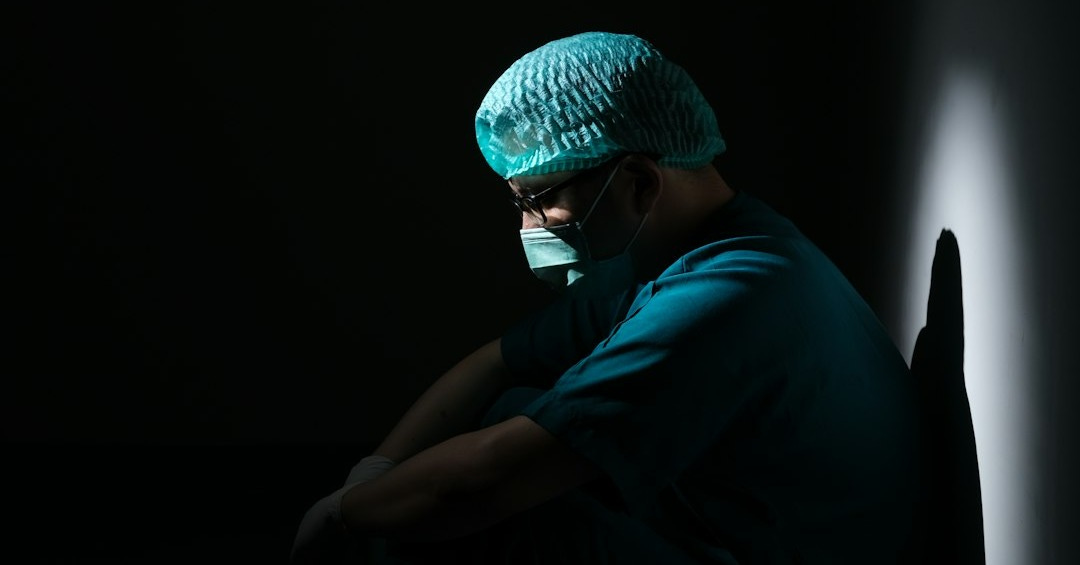 man in green shirt and blue knit cap sitting on floor