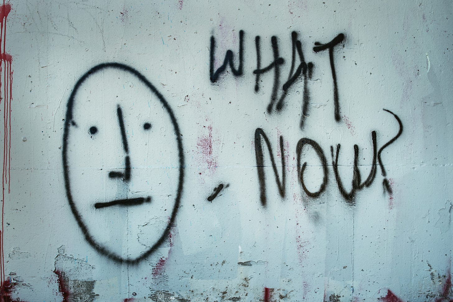 graffiti on crumbling wall says what now