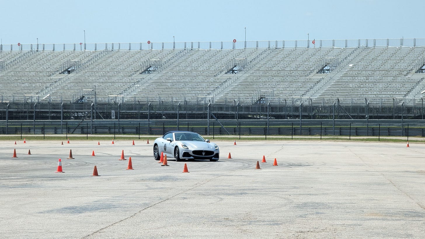 A silver Maserati GranCabrio driving between cones on an autocross course