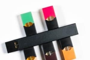 E-cigarette or nicotine vapor stick and flavor dispensers on white background