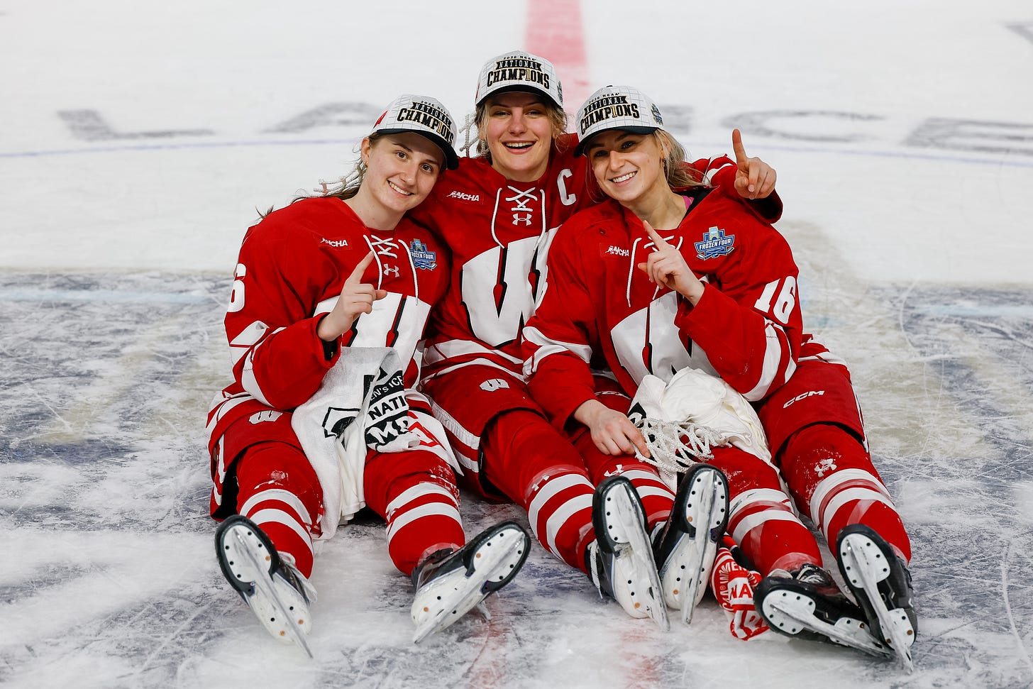 Wisconsin Badgers hockey players pose at center ice for a post-game photo