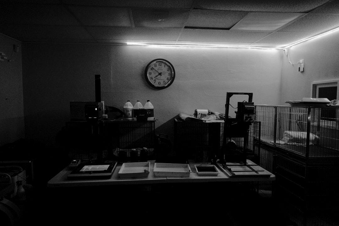 a dimly lit room with a clock on the wall a dimly lit room with a clock on the wall