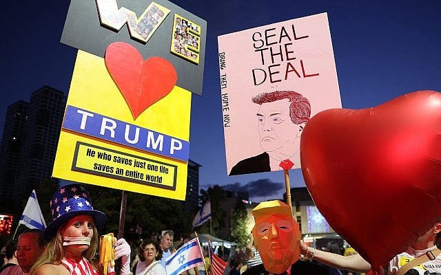 A man wearing a mask of US President Donald Trump holds a heart-shaped balloon during a rally organized by families of hostages held by Palestinian terrorists in the Gaza Strip since October 2023, in the plaza outside the Tel Aviv Museum of Art known as the "Hostages' Square," on October 4, 2025. (Jack Guez/AFP)