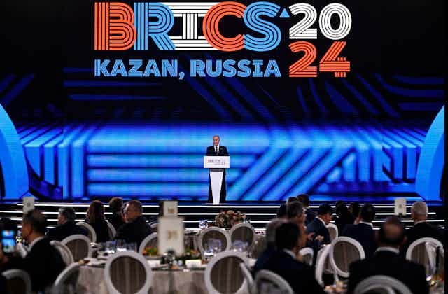 A man in suit addressing a large gathering A man in suit addressing a large gathering
