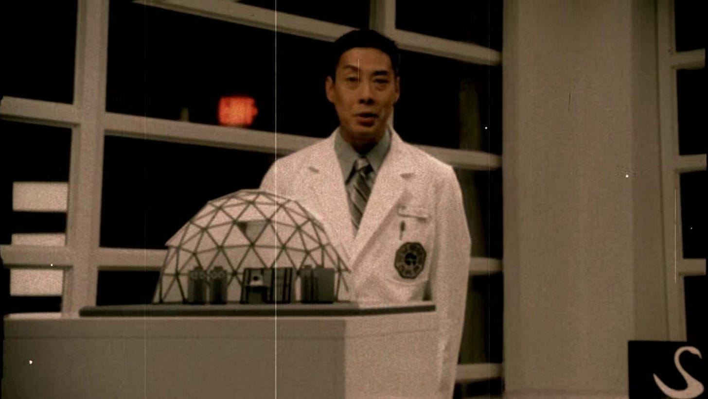 Dr. Marvin Candle appears in a scratched and aged film. He stands next to a model of the Swan Station.