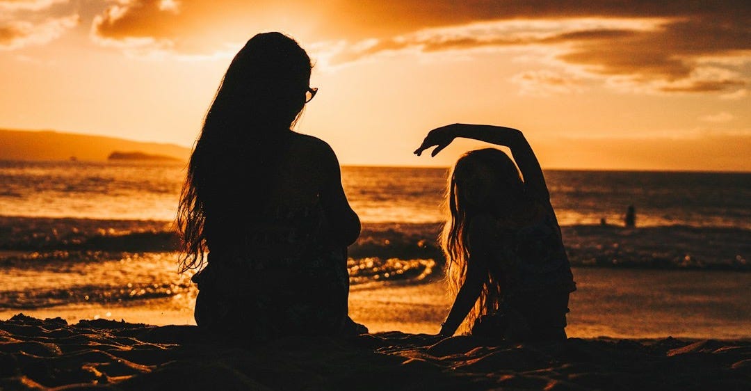 silhouette photo of woman and girl on shoreline