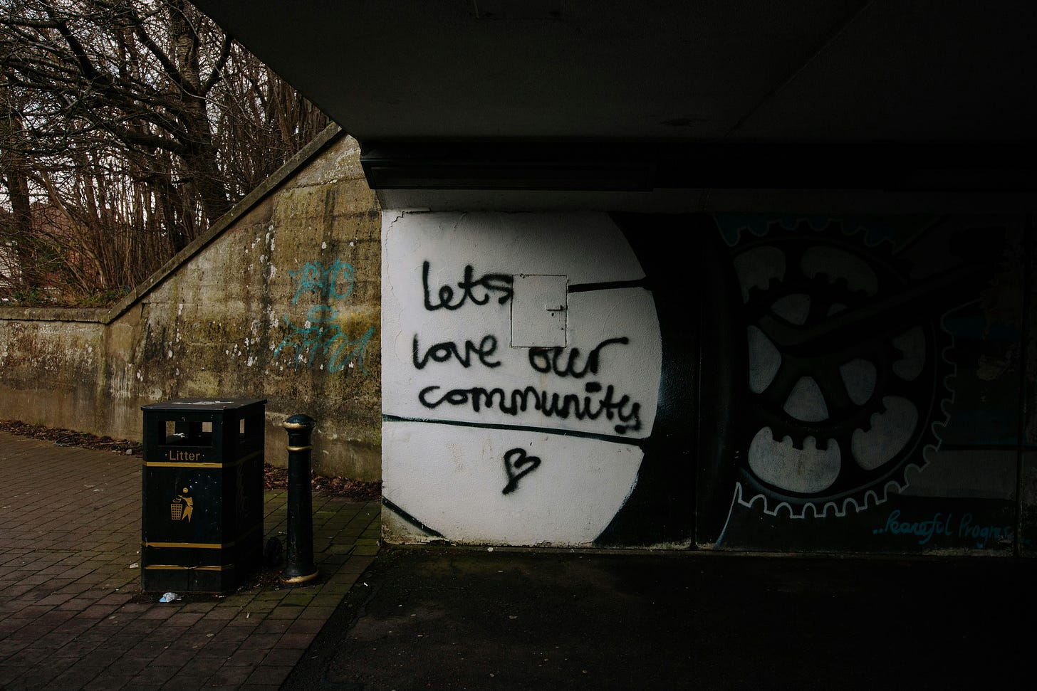 An underpass with graffiti that reads "Let's love our community". An underpass with graffiti that reads "Let's love our community".
