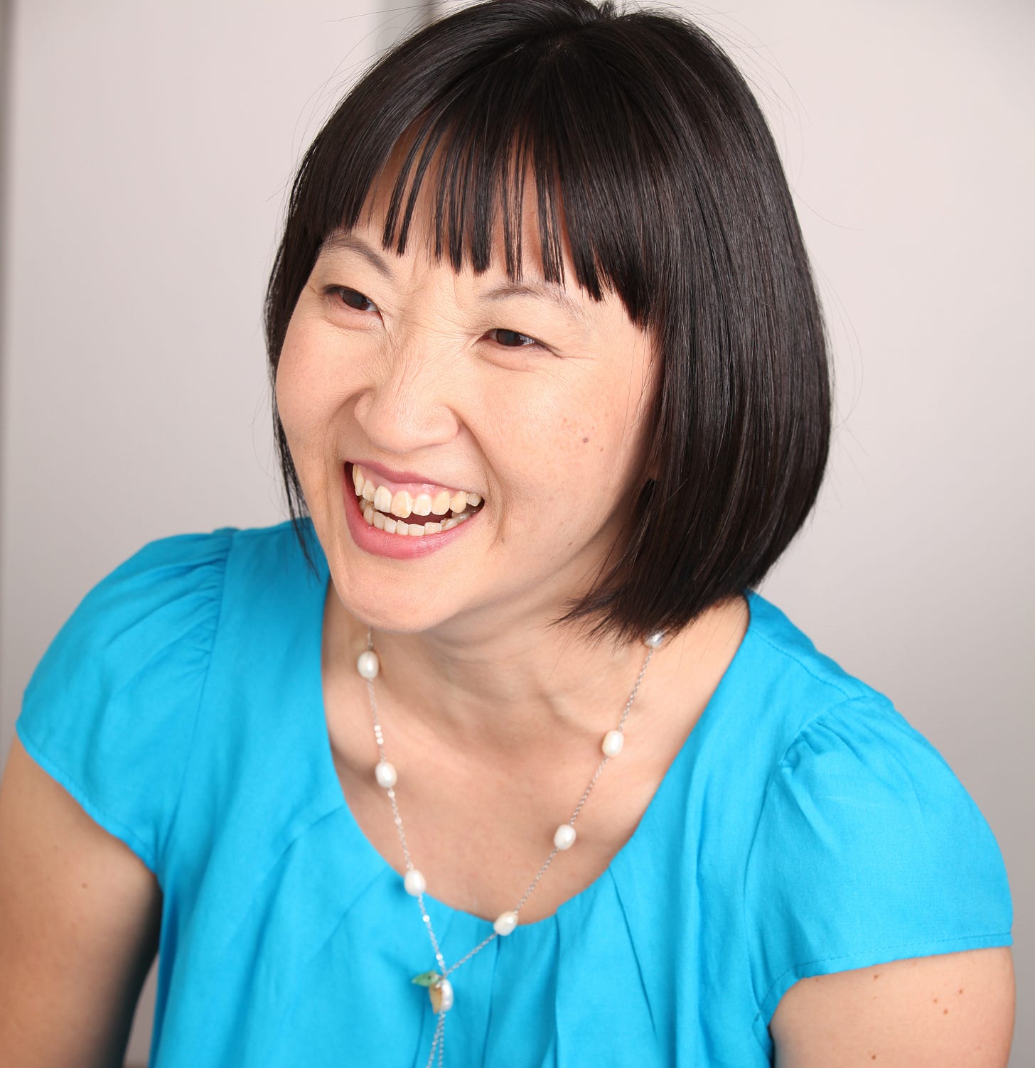 Stacy S. Kim Smiling Korean woman in a bright blue shirt