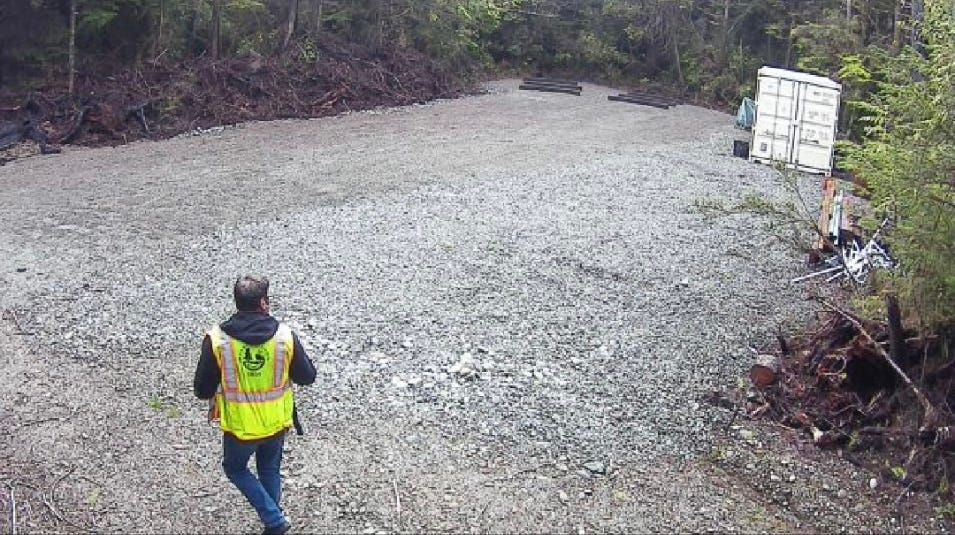 A few men walking on a gravel road

Description automatically generated