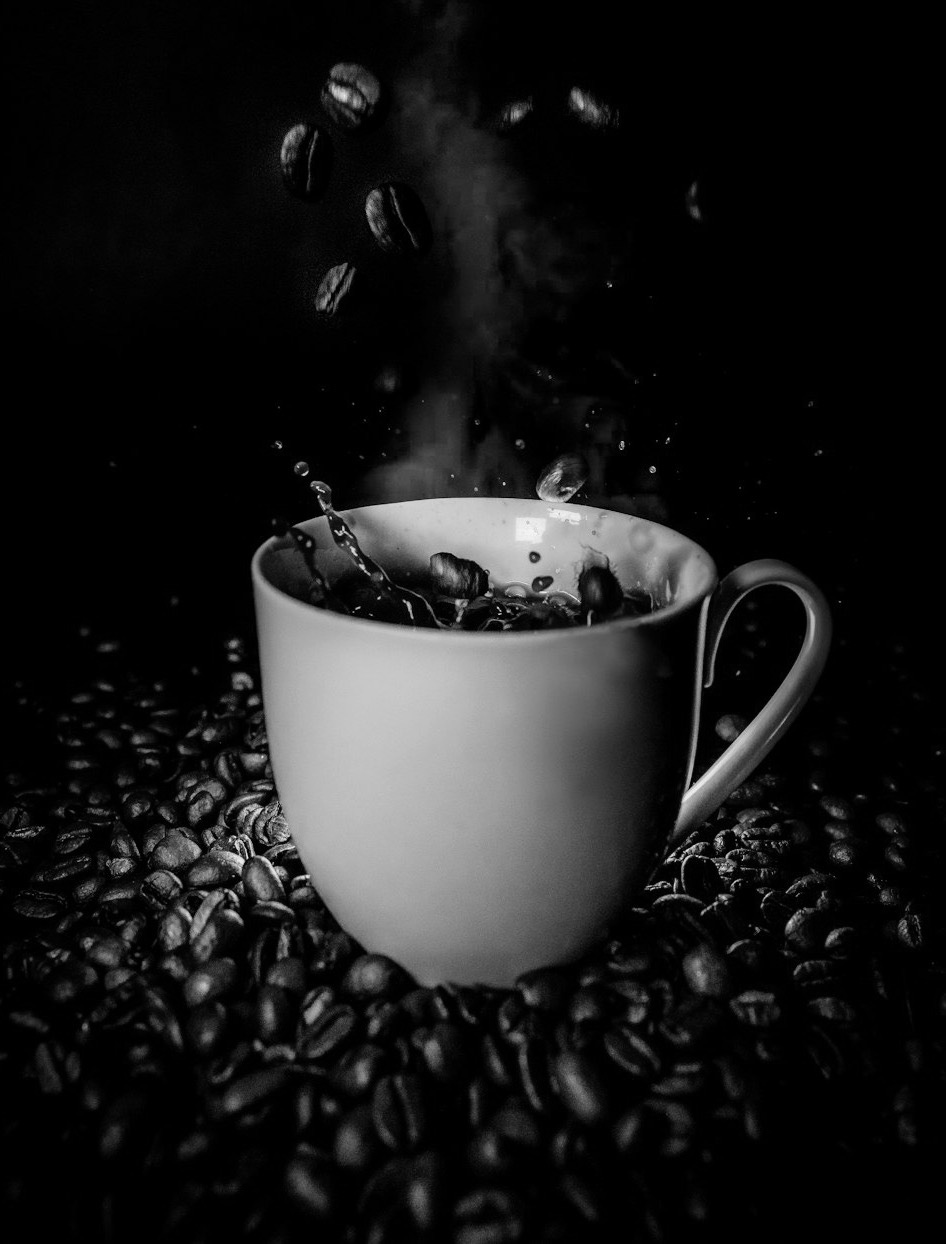 white ceramic teacup with coffee beans