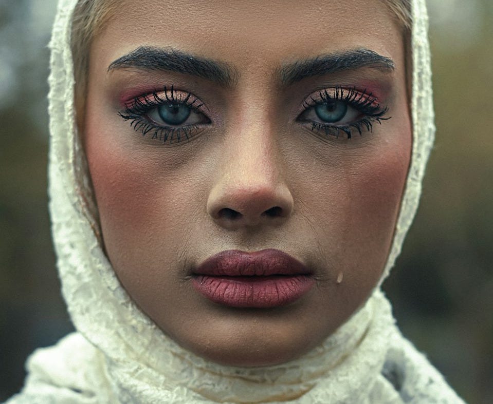 A woman is wearing a headscarf, looking sad. A woman is wearing a headscarf, looking sad.