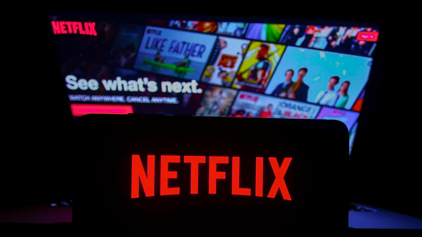 Netflix logo is displayed on a mobile phone screen with Netflix website in a background for illustration photo. Krakow, Poland on January 23, 2023. (Photo by Beata Zawrzel/NurPhoto via Getty Images)