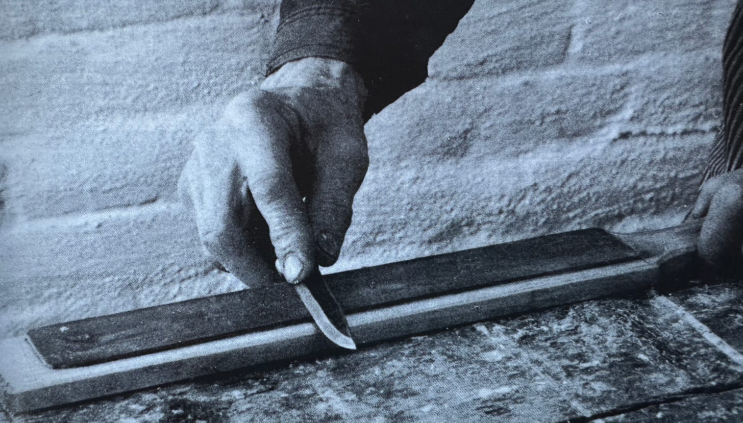 Knife blade being sharpened on a whetstone