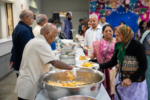 A group of people lined up for a buffet in a Hindu temple cafeteria.