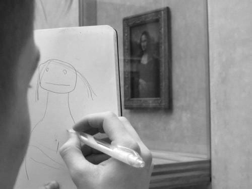 This may contain: a person drawing on a piece of paper in front of a painting with a woman's face